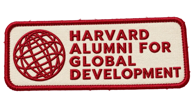The Harvard Alumni for Global Development globe embroidered in crimson on a cloth patch
