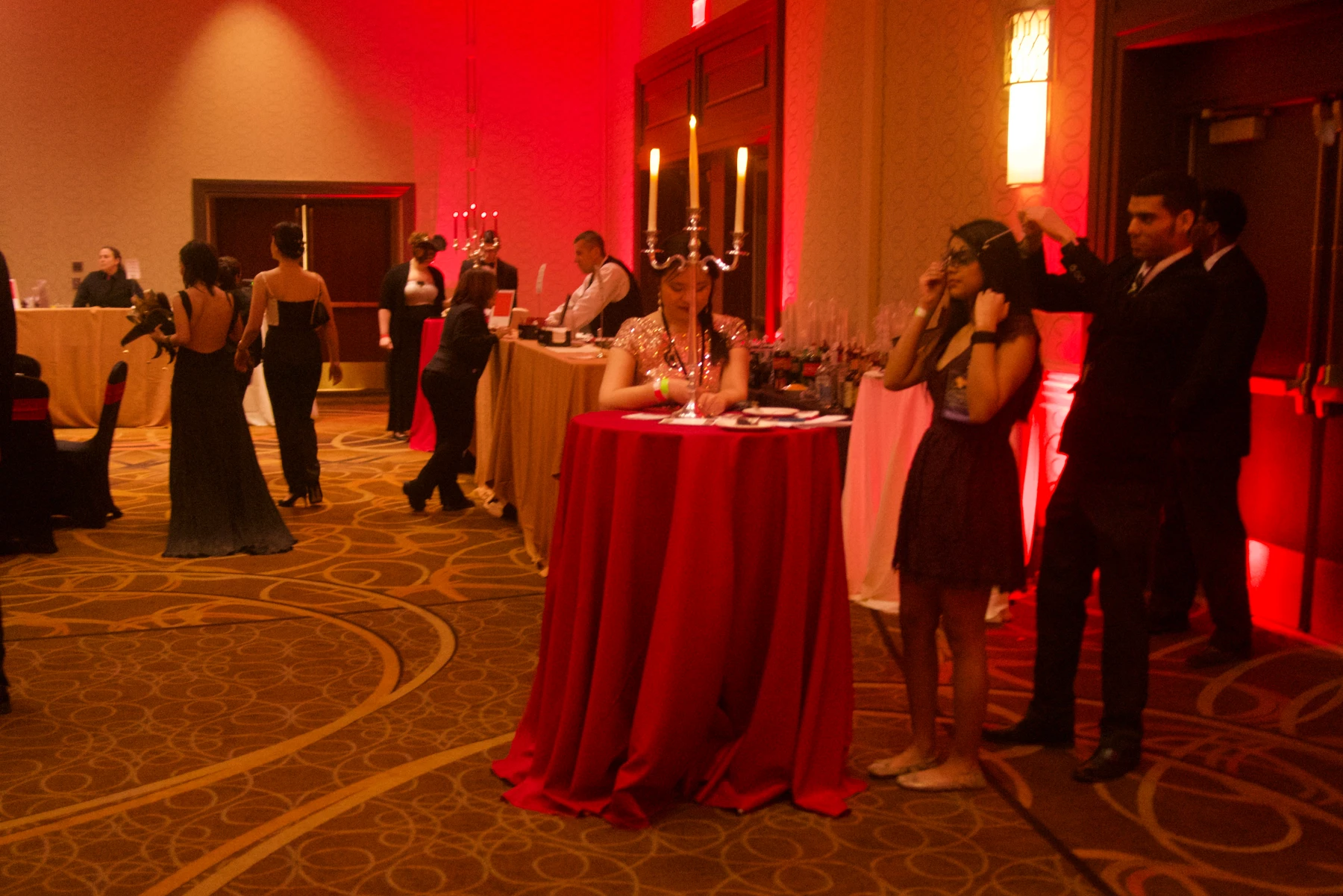 Guests gathered around candlelit tables at the masquerade ball