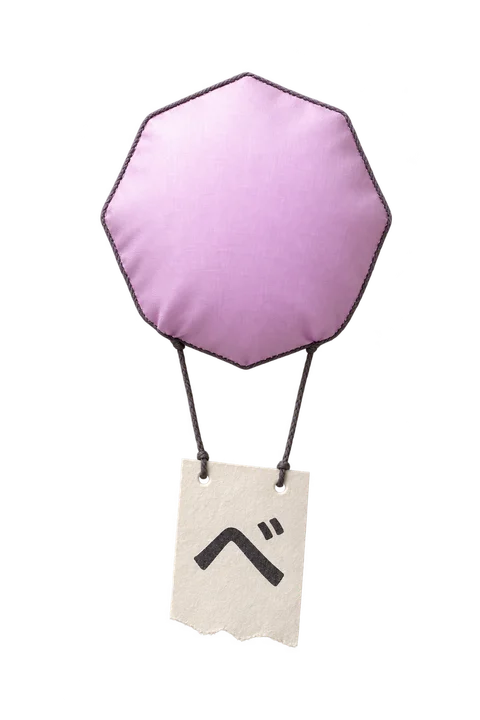 The original lilac NihongoUp balloon design as a cloth object, carrying a paper kana ticket
